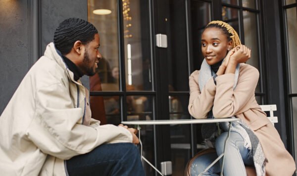 Two young people sitting outside. African couple enjoying the time spending with each other.